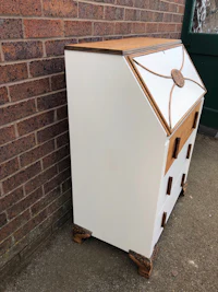 a white and brown desk with drawers in front of a brick wall