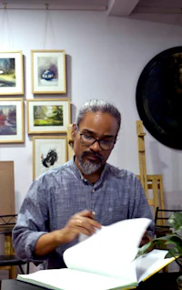a man sitting at a table with a book in front of him