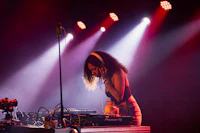a woman djing on stage in front of red lights