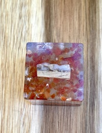 a small box with a piece of red and orange agate