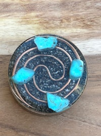 a copper and turquoise spiral ring on a wooden table