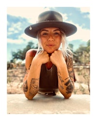 a woman wearing a hat with tattoos