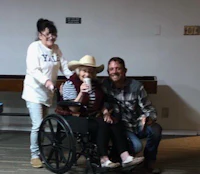a woman in a wheelchair is posing for a picture with a man