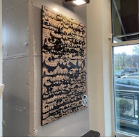 a piece of art hanging on the wall of a coffee shop