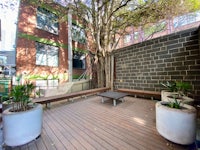 a wooden deck with a tree and potted plants