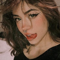 a girl is posing with her tongue out