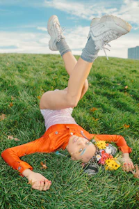 a woman laying on her back in the grass