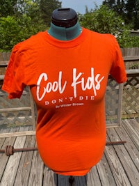 an orange t - shirt that says cool kids don't die