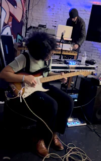 a woman playing guitar in a recording studio