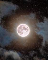 a full moon in the sky with clouds