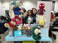 a group of women pose in front of a table full of stuffed animals