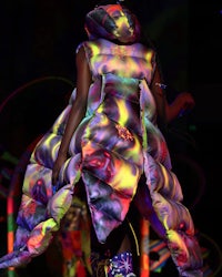 a woman wearing a colorful dress on a runway