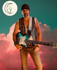 a man holding an electric guitar in front of clouds