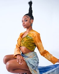 a black woman in a tie dye top and skirt