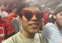 a man wearing red heart shaped sunglasses in a crowd