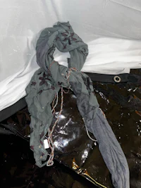 a black blanket with a scarf on it