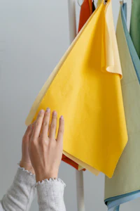 a woman is putting different colored paper on a hanger