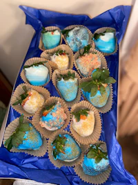 a blue box filled with blue and white frosted strawberries