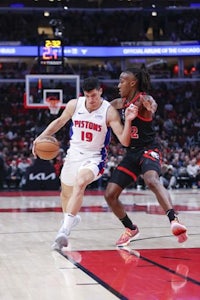 detroit pistons guard person drives past chicago bulls guard person during the first half of an nba game