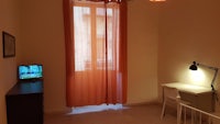 a small room with an orange curtain and a tv