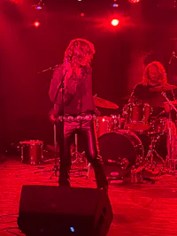 a group of people on stage with a red light behind them