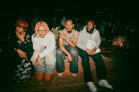 a group of people sitting on a wooden floor
