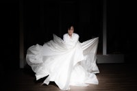 a woman in a white dress in a dark room