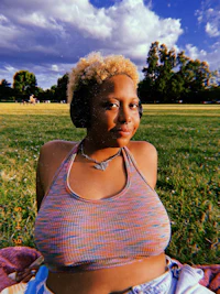 a woman laying on a blanket in a grassy field