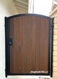 a wooden gate with a black handle on it
