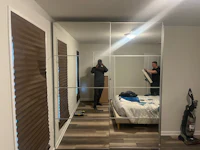 a man is standing in front of a mirror in a bedroom