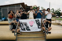 a group of people posing for a photo with a banner