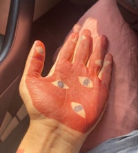 a person's hand with red paint on it
