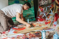 a man working on a painting in his studio