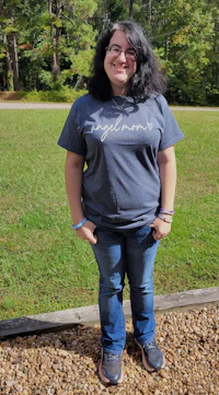 a woman wearing jeans and a t - shirt standing in a field