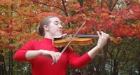 a young girl playing the violin in the fall