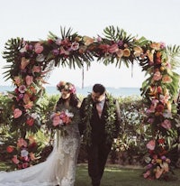 a bride and groom walking down the aisle at a hawaiian wedding
