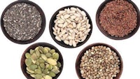 a variety of seeds and nuts in bowls on a white background