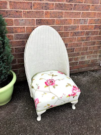 a wicker chair with a floral upholstered seat