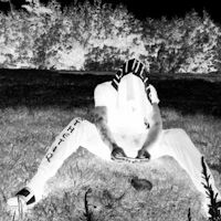 a black and white photo of a person sitting in the grass