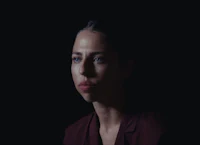 a woman is staring into the dark