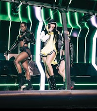 a group of women in black outfits on a stage