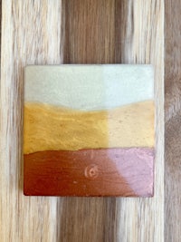 a ceramic coaster with a yellow, orange, and brown color