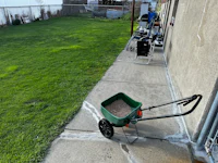 a wheelbarrow filled with sand on a sidewalk