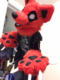 a red fox mascot with claws on his feet