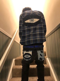 a man standing on the stairs with an eye patch on his jacket