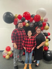 a family posing in front of a balloon arch