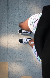 a person standing on a sidewalk wearing a pair of shorts