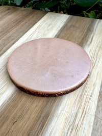 a round copper plate on top of a wooden table