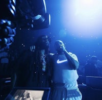 two men standing next to each other at a concert