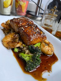 a plate of food on a table next to a glass of wine